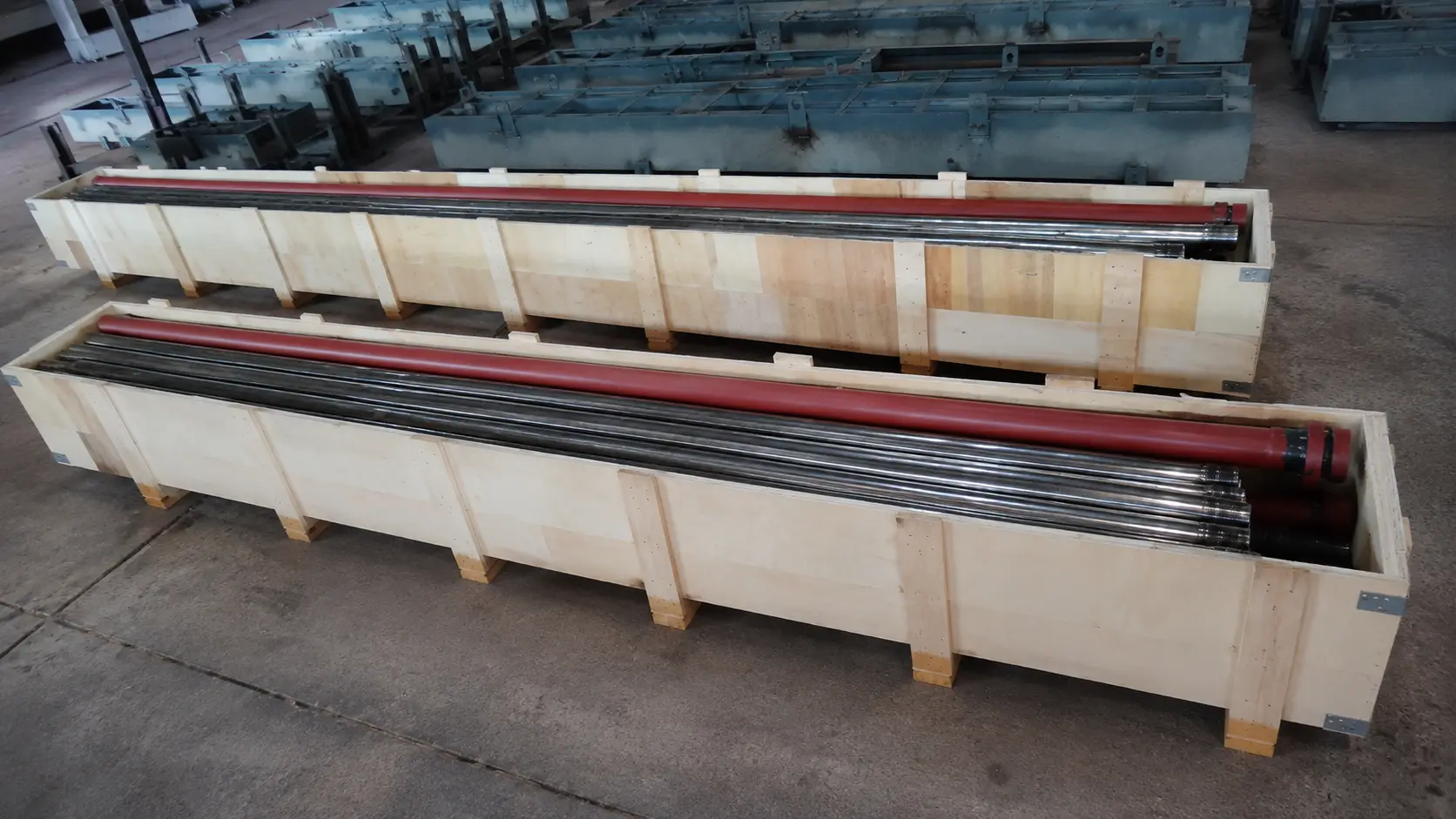 Sootblower lance tubes packaged in crates on a warehouse floor.